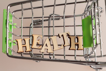 shopping cart with the inscription health lined with letters, the concept of a healthy person, money can not buy a health