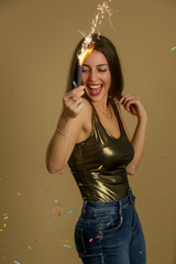 Fototapeta premium Happy laughing woman in metallic shirt holding sparkling stick, party season concept 