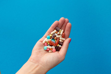 A handful of colored pills on the palm. Medical concept. Shopping at the pharmacy.