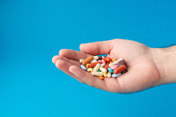 A handful of colored pills on the palm. Medical concept. Shopping at the pharmacy.