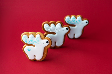 gingerbread cookie of little cute deer on red background. Traditional Christmas food. Christmas and New Year holiday concept.