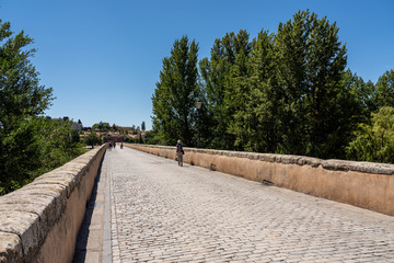 Fototapeta na wymiar Cobbled surface of the old Roman Bridge leading away from the city of Salamanca in Spain