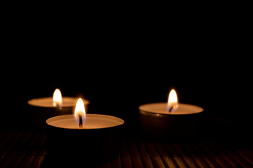 Fototapeta na wymiar Three burning candles, close up and selective focus on foreground