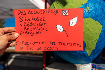 Close up of french poster hand made by climate change activists at an ecological protest. Banner inviting the community to Recycle, reduce and reuse.