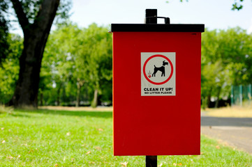 Red bin and black lid for box poo in the park
