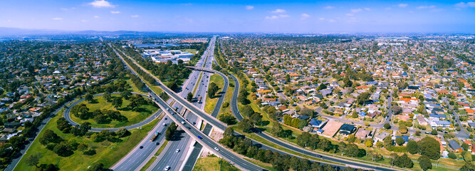 Scenic aerial panorama of highway interchange in greater Melbourne suburbs on sunny day - 302097149