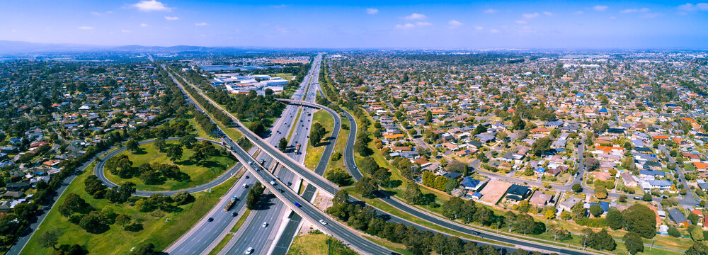 Scenic aerial panorama of highway interchange in greater Melbourne suburbs on sunny day