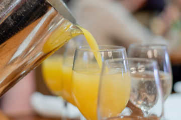 Making mimosas - adding a splash or orange juice to the champagne - 302097737