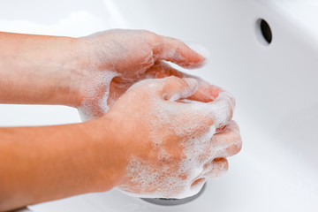 Fototapeta premium Hygiene concept. Washing hands with soap under the faucet with water