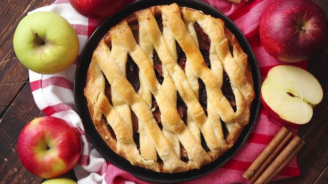 Homemade pastry apple pie with bakery products on dark wooden kitchen table