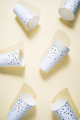 New year party theme conceptual image, top view of flat layout composition of paper glass with golden decoration, empty, on a yellow pale background, copyspace