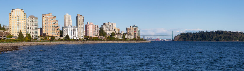 Fototapeta na wymiar West Vancouver, British Columbia, Canada. Beautiful panoramic view of residential buildings on Pacific Ocean Coast during a sunny summer evening.