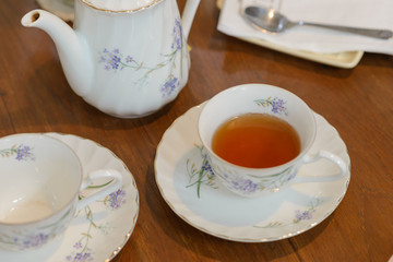 Teapot and cup of tea on wooden table. vintage style of tea set