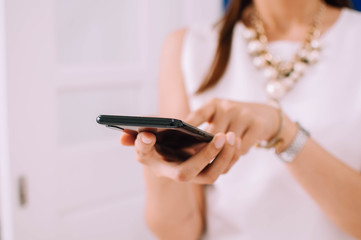 A young woman is using a smartphone indoor