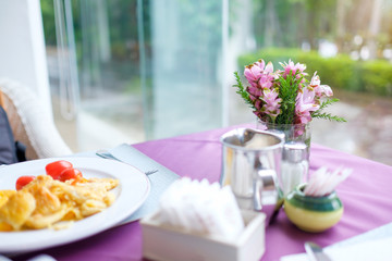 Delicious omelette served for breakfast on table in beautiful restaurant at hotel with copy space / Shallow depth of field, selective focus