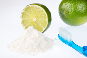 Fresh sliced lime, baking soda and toothbrush - Text space