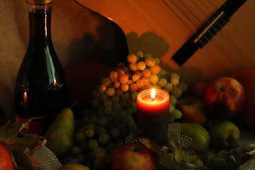 Autumn warm scene. Stll life harvest. Thanksgiving post card greetings. Candle flame with ripe...