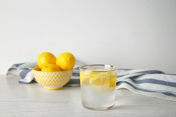Glass of fresh lemonade on table