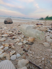 Fototapeta na wymiar glass bottel wastes on the beach has sand pollutants that damage the environmental and humans 
