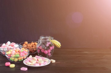 multi-colored candies in a plate, bank and bowls with copy space