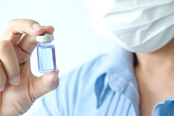 Fototapeta premium doctor's hand, he holds a bottle of antiretroviral drugs, blue water. Health and medical concepts