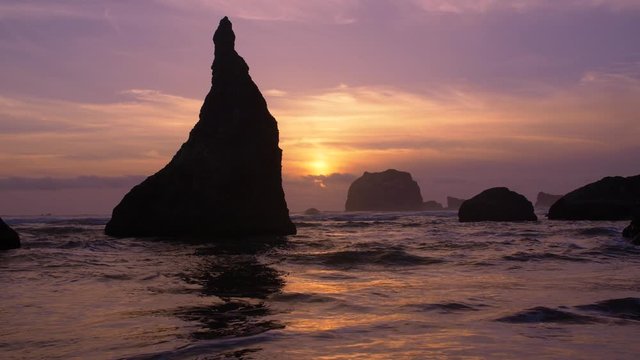 Golden sunset graces Bandon beach during a colorful moment on the rugged Oregon coastline