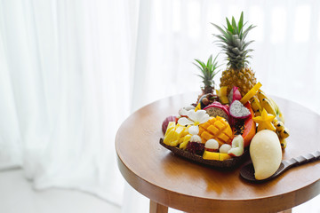 Juicy ripe tropical Thai fruits on a wooden dish.