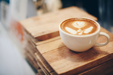 Coffee cup with latte art on the wood table