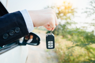 Business man showing a car key
