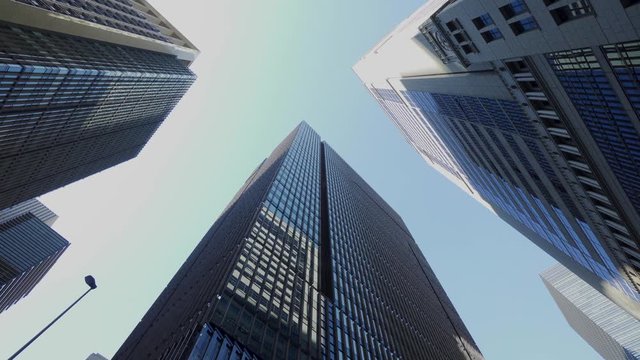 大手町ビジネス街の風景 歩き撮り / A dolly shot of a business district lined with skyscrapers. Cityscape of flowing buildings and signals. Chiyoda, Tokyo, Japan.