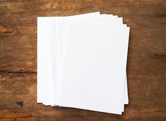 Poster mock-ups paper, white paper isolated on wood background, Blank portrait A4 brochure magazine, can use banners products business cards to showcase your.