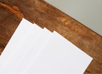 Poster mock-ups paper, white paper isolated on wood background, Blank portrait A4 brochure magazine, can use banners products business cards to showcase your.