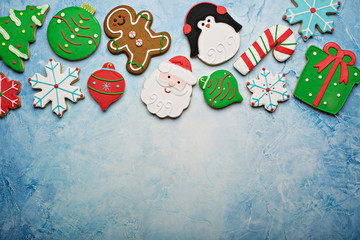 Christmas sugar and gingerbread cookies decorated with royal icing on a light blue surface