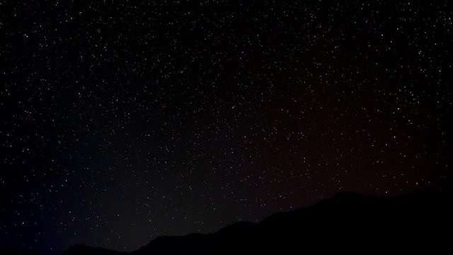 Night sky timelapse over a hill as seen from Bhujung Village, Lamjung, Nepal. Long Exposure, wide shot.