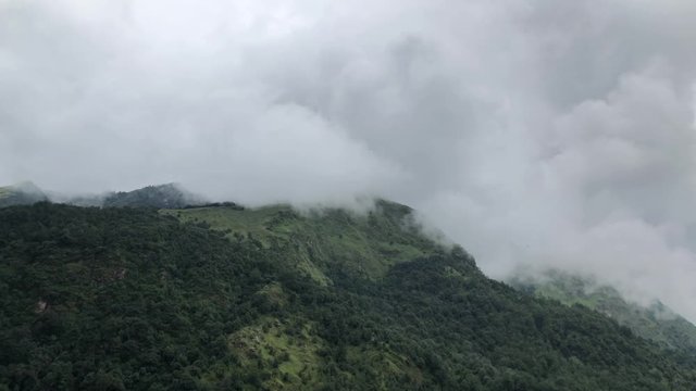 Day timelapse of clouds movement over the top of a hill on a cloudy day. Wide shot and was taken on the way to Poon Hill, Kaski, Nepal while trekking.
