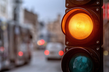 A city crossing with a semaphore. Orange light in semaphore - image