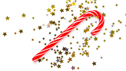 Christmas striped candy on white background with confetti. Flat lay. New Year mood