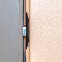 Square Close up of locked deadbolt latch on home door