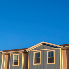 Square Focus on the upper storey of townhomes with blue sky background on a sunny day