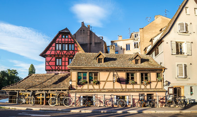 Several bicycles are located along the old houses in Strasbourg, France