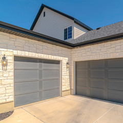 Square frame Three car garage and driveway of suburban home