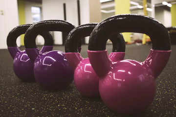 Naklejka na ściany i meble multi-colored kettlebells in the gym, the concept of sports and physical activity