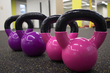 Naklejka na ściany i meble multi-colored kettlebells in the gym, the concept of sports and physical activity