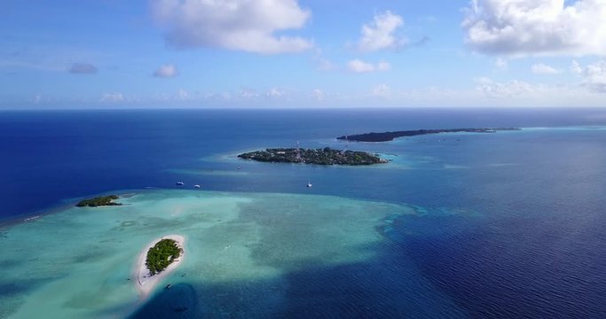 Tonga Islands - Close Contact Of Deep Blue Ocean And Shallow Green Ocean Surrounding Small Islands Under The Bright Cloudy Sky - Aerial Shot 