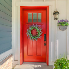 Square frame Red front door of modern home with green wreath