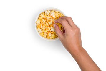 Top view of The hand is picking a popcorn coated with golden yellow caramel looks tasty on white background with clipping path.