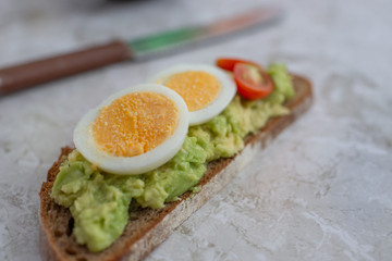 sliced avocado and egg on toasted bread for healthy breakfast
