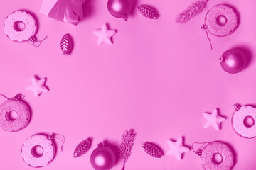 paper pink background with Christmas decoration balls, donuts, gift and stars.   flat lay, top view. Christmas card conception. Toned into pink color