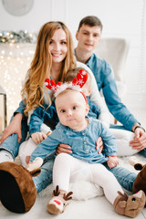 The father, mother holds little son and daughter near Christmas tree. Happy New Year and Merry Christmas. Christmas decorated interior. The concept of family holiday. Close up.