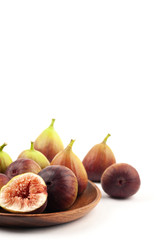 fig fruits and one cut figs in wooden bowl on white background